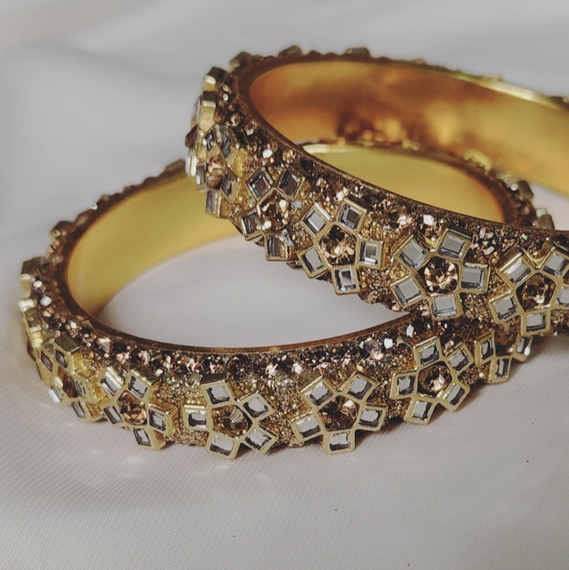 Floral-patterned lac-metal bangles in Kangan style, studded with elegant Kundan stones