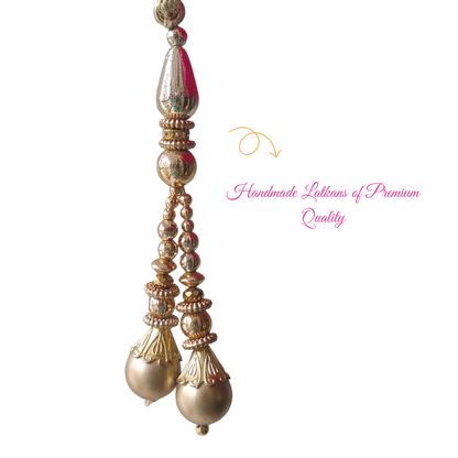 Decorative handmade gold Latkan with intricate designs on a white background
